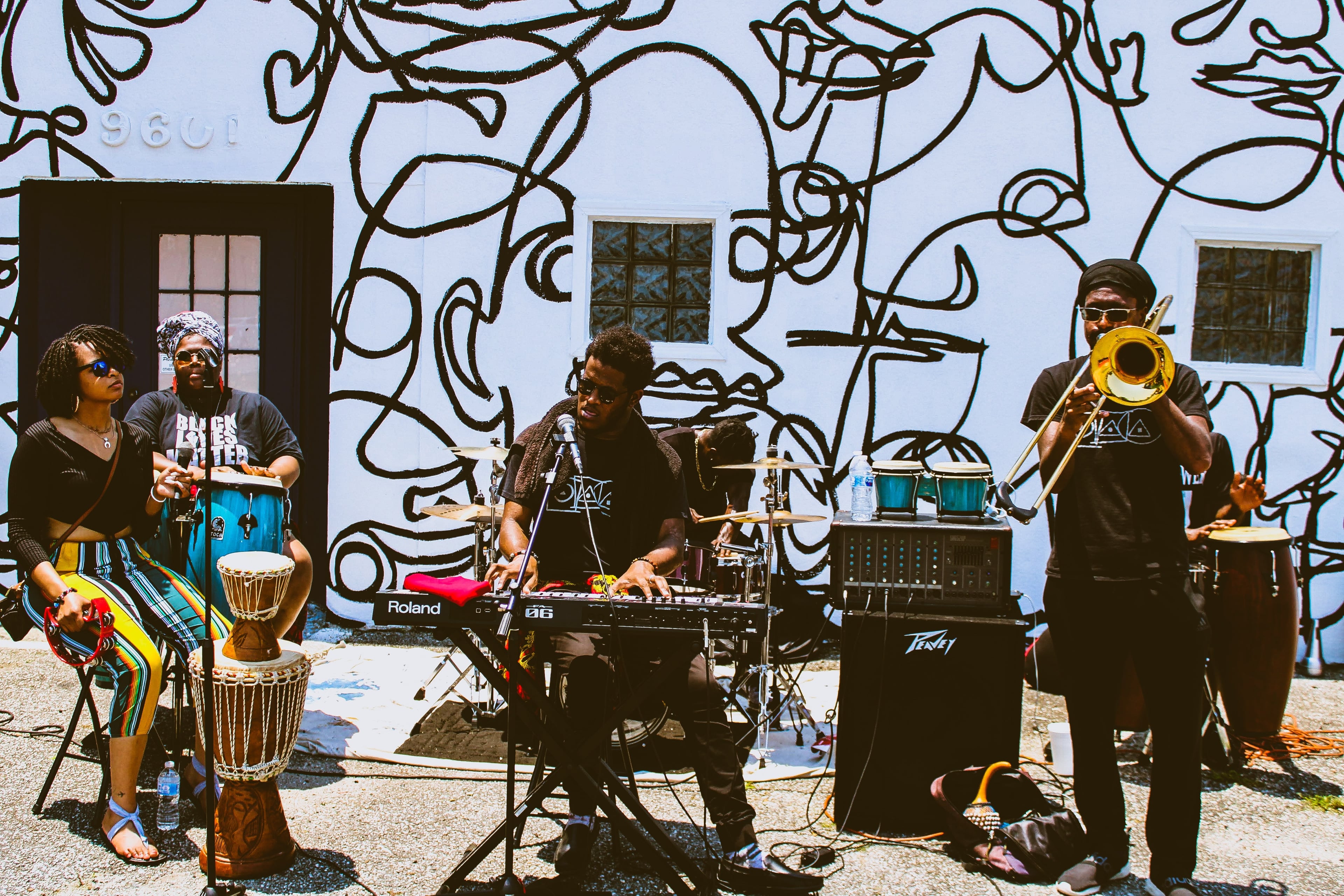 A live band performing under violet stage lights